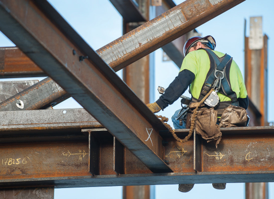 Construction worker sitting on steel beam