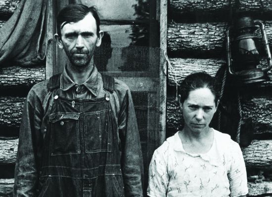 Man and woman standing outside log cabin