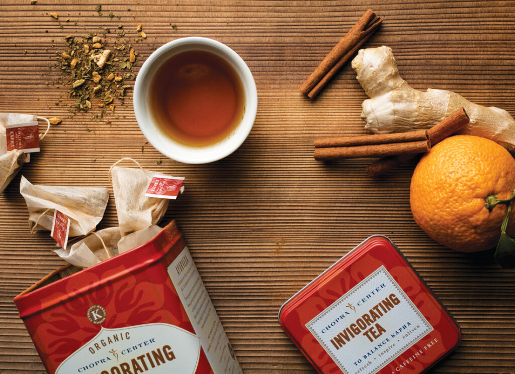 Harney Invigorating Tea flat-lay with tea bags, ginger, cinnamon and orange