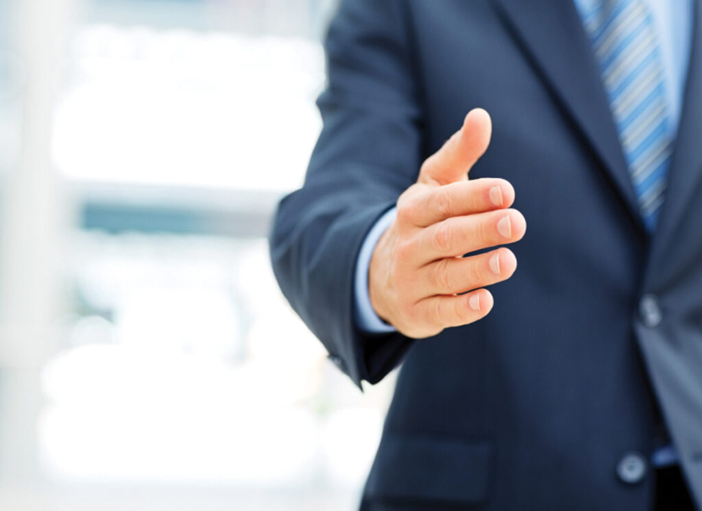 Man in blue suit reaching out for handshake