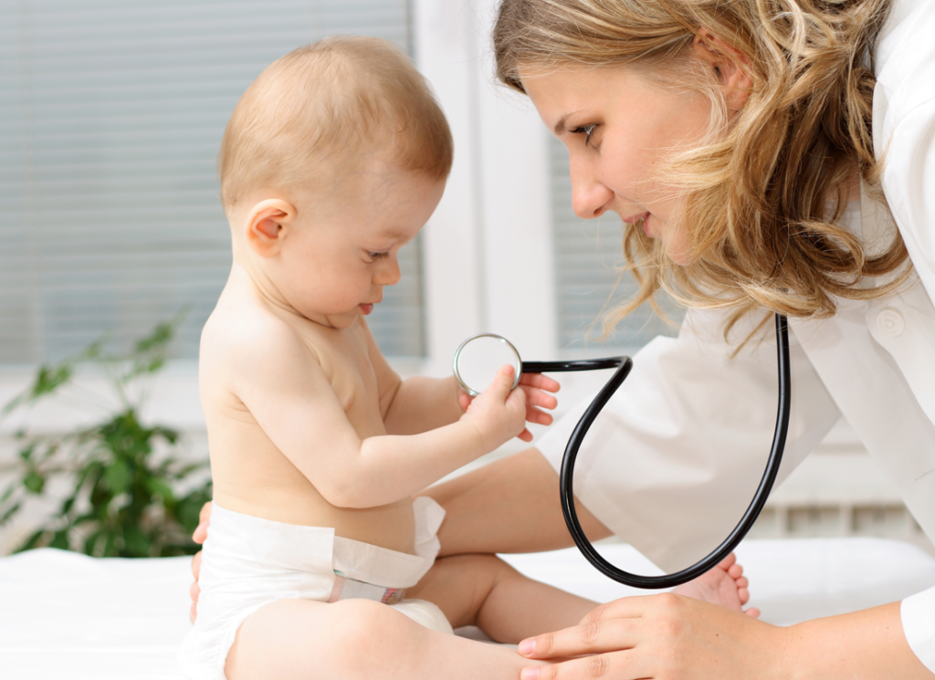 Doctor checking baby while it plays with her stethoscope