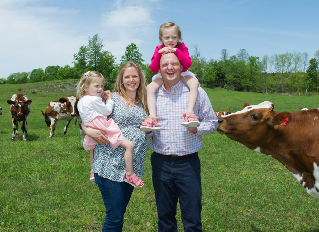 Family of 4 in field with cows