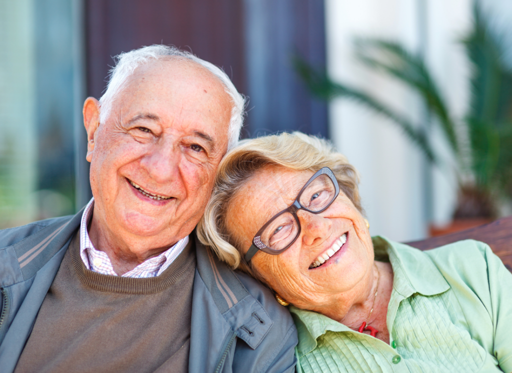 Woman wearing glasses resting head on man's shoulder