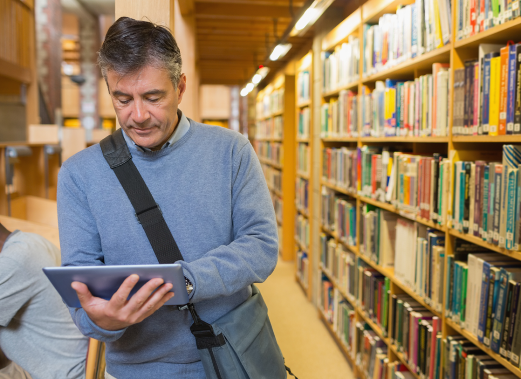 Man with tablet in library